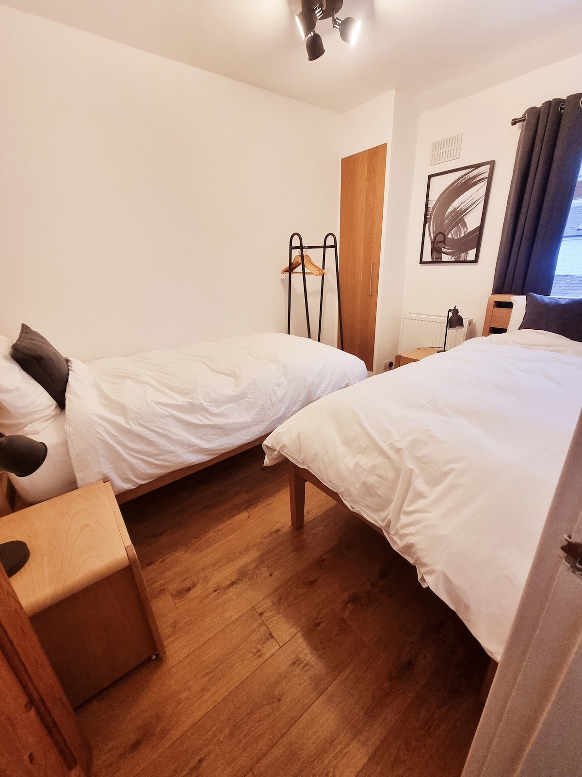 Druhá spálňa ponúka dve samostatné postele s plyšovou posteľnou bielizňou, nočné lampy na útulné osvetlenie a vešiak na oblečenie pre vaše pohodlie. Je to pohodlné miesto ideálne na pokojný nočný odpočinok po dni strávenom v Lancasteri.