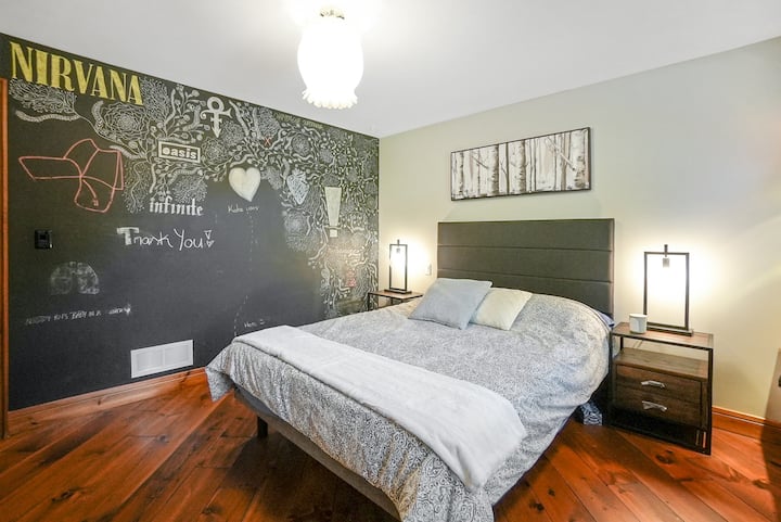 楼上的第一间卧室有一张双人床和一面粉笔墙。