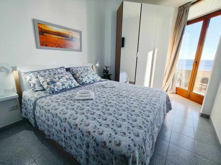 Spálňa so sieťou proti komárom na kolieskach, klimatizáciou a televízorom je vybavená okennými dverami s výhľadom na verandu.