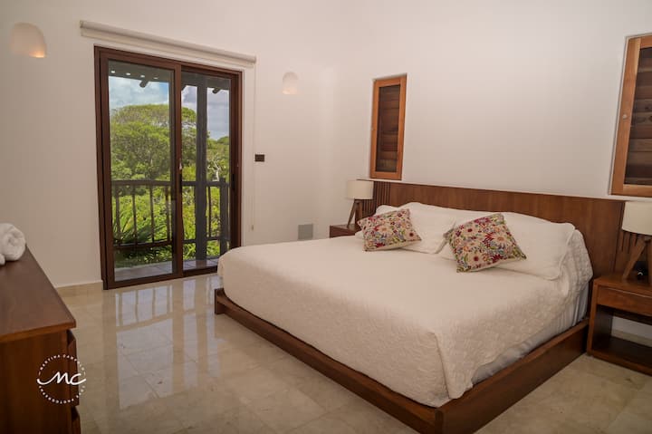 Уютна спалня с дървен декор и естествено осветление.