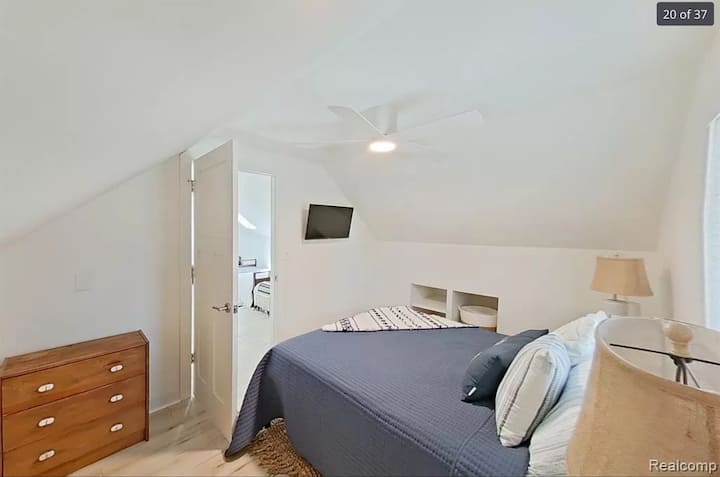 Cama tamaño queen con ventilador de techo. 