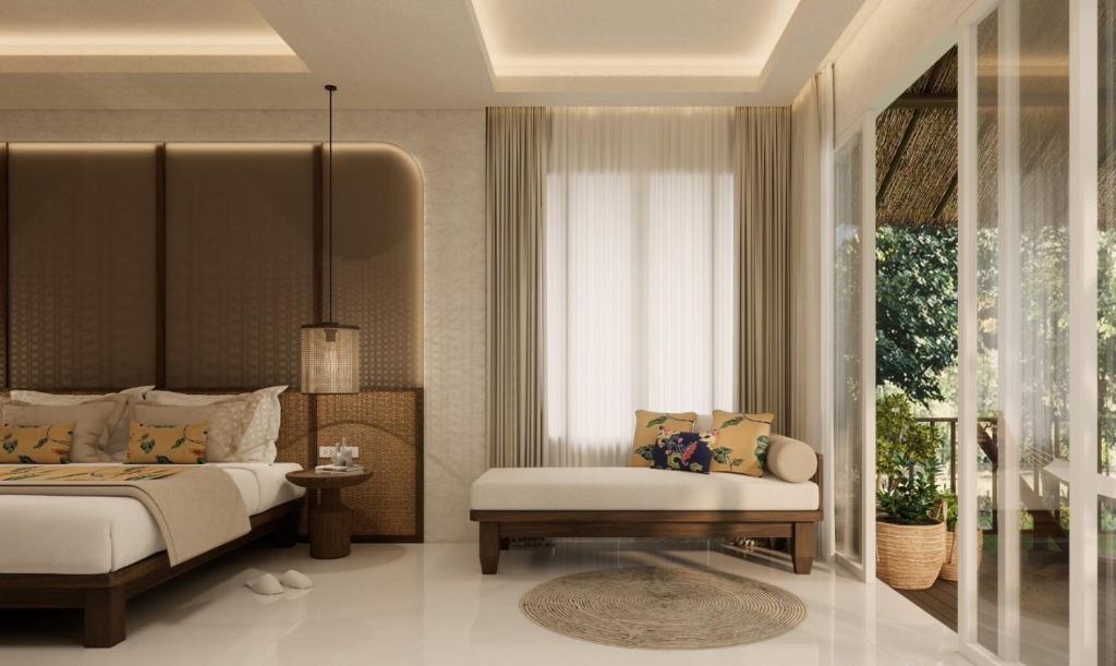 A well-appointed room features a spacious bed adorned with decorative pillows. A comfortable daybed sits nearby, complemented by a round rug. Natural light pours in through large glass doors that open to a private terrace with a view of greenery.