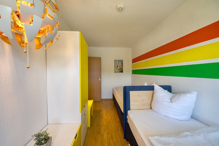 Dormitorio 2 con  armarios y dos cómodas camas de somier de 90x200 cm, así como un rincón de lectura con pufs.