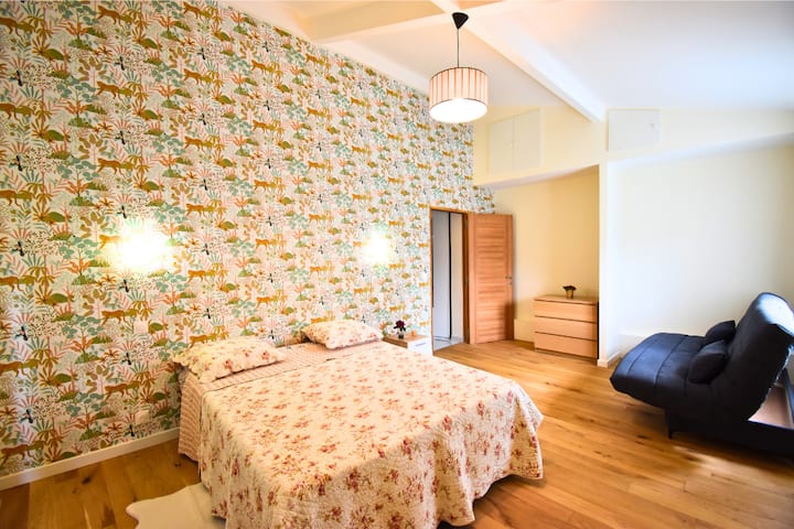 غرفة نوم رئيسية أنيقة مع سرير بحجم كبير لليالي مريحة، يكملها سرير أريكة لمنطقة استراحة إضافية أو سرير إضافي.