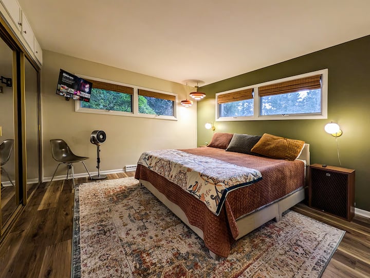 Disfruta de un espacioso dormitorio principal con cama tamaño king y espejos de pared.