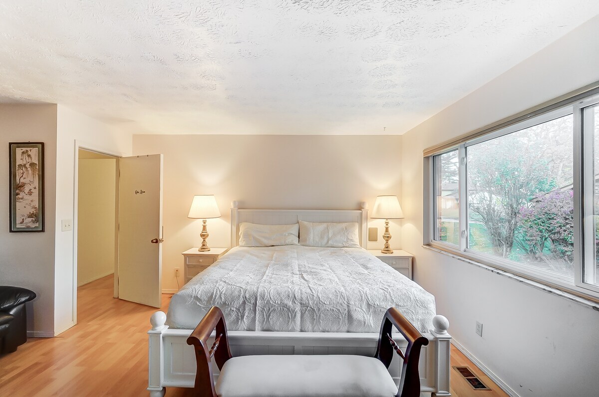 Dormitorio enorme con cama tamaño king de California.