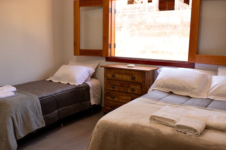 Quarto com janela e cama de casal e de solteiro