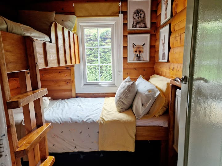 A beautiful second bedroom, with L- shaped single bunk beds, perfect for children and adults alike, featuring soft linens and beautiful woodland animal artwork. 