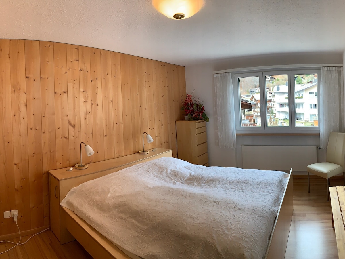 Großzügiges Schlafzimmer mit Doppelbett und viel Stauraum für längere Aufenthalte. Blick auf Madrisa.