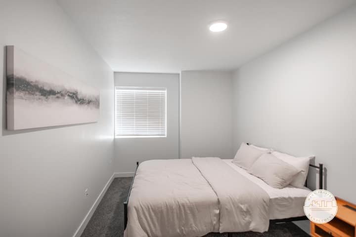 Chumba cha kulala chenye nafasi kubwa kilicho na kitanda kizuri, mapambo maridadi na dirisha kubwa. Palette laini, isiyoegemea upande wowote na muundo rahisi hutoa mapumziko ya amani wakati wa ukaaji wako.