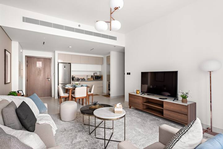 Ფართო მისაღები ოთახი დიდი კაბრიოლეტით, დახვეწილი ყავის მაგიდით, კომფორტული სავარძლით და 65-დუიმიანი ტელევიზორის ეკრანით თქვენი გართობისთვის. Გადაჰყურებს სასადილო სივრცესა და სამზარეულოს. 