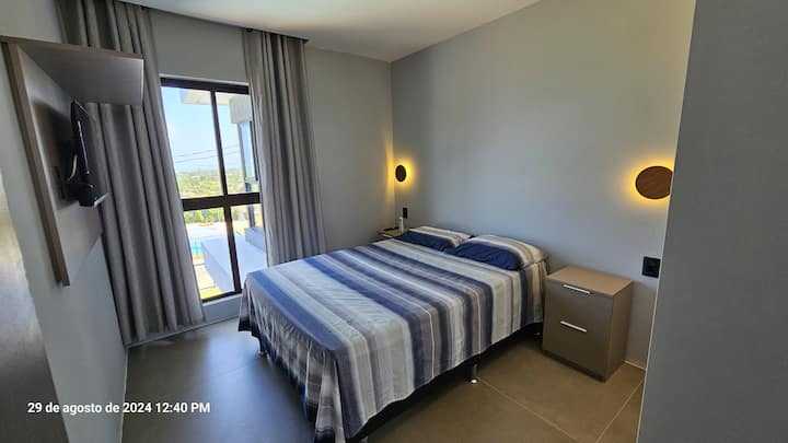 Habitación 2 del piso superior, con una cama doble y un auxiliar debajo, TV de 32pulgadas, armario, sirvientes mudos, iluminación junto a la cama y aire acondicionado. Vista al mar de Ponta de Pedras.