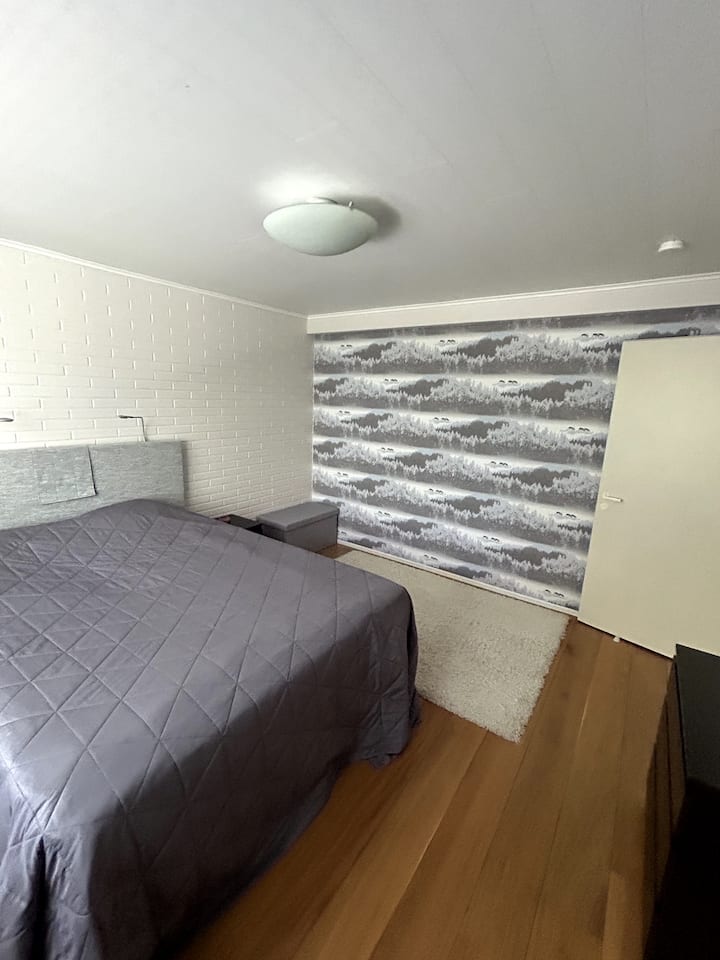 Spálňa má 160 cm širokú manželskú posteľ, pohodlný prístup na zadnú terasu a dvor. Nočné stolíky.