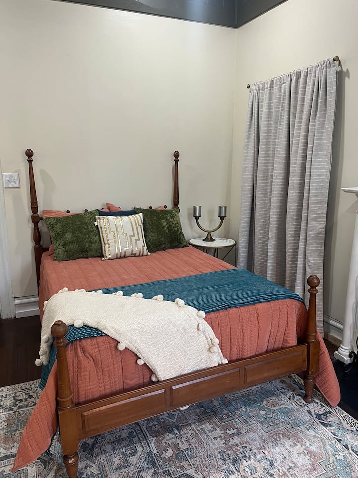 Este dormitorio tiene una cama doble, una hermosa cómoda antigua y un gran ventilador de techo.