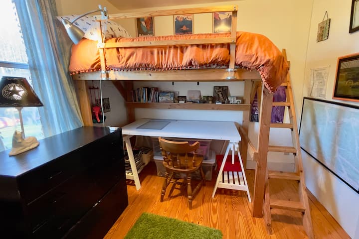 سرير مزدوج علوي ومكتب للكتابة في الأسفل. كتب وألعاب للأطفال.