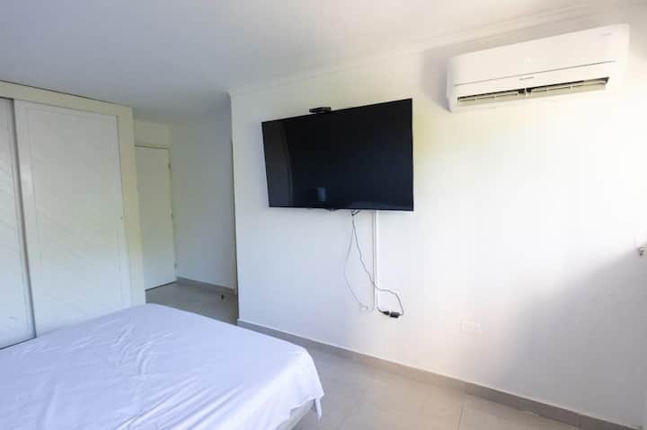 Chambre avec un lit confortable qui vous offre le meilleur repos, une télévision pour que vous puissiez profiter de vos émissions préférées et la climatisation pour plus de fraîcheur