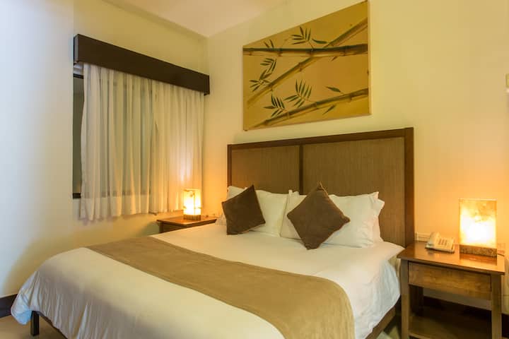 Détendez-vous dans ce lit king size confortable, entouré d'une ambiance chaleureuse et calme. L'éclairage doux et la décoration minimaliste invitent au repos, créant l'espace parfait pour une nuit de sommeil réparateur