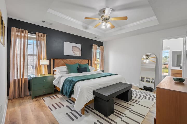 Unwind in the master bedroom with plush bedding and a private en suite bathroom for ultimate comfort and convenience.