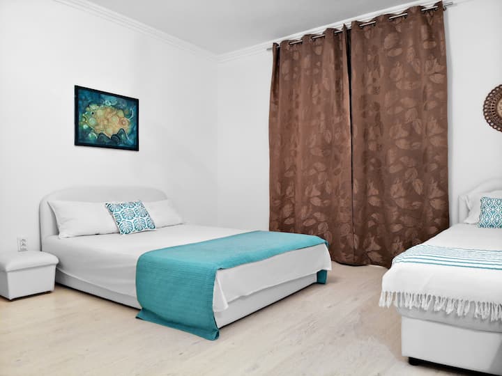 Stan s 3 spavaće sobe ima jedan bračni krevet, jedan jednostruki krevet, ormar i pogled na našu glavnu zajedničku terasu.