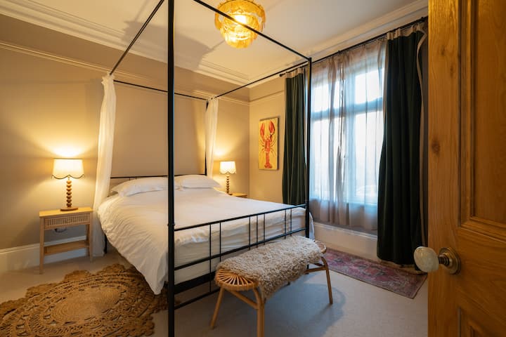 Bedroom 2 is warm and inviting, featuring a king sized four poster bed and room darkening curtains to guarantee a restful night