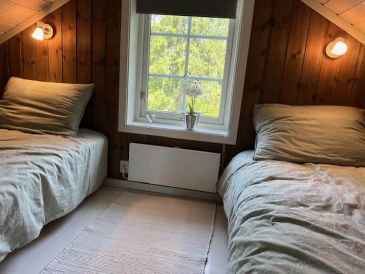 Soveværelse med to enkeltsenge på anden sal. Der er et skråt loft og ca. 185 cm på det højeste.