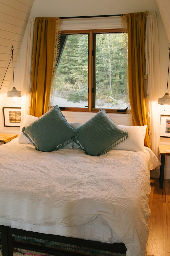 Plyšová manželská posteľ veľkosti King s prémiovou posteľnou bielizňou a zobuďte sa s úchvatným výhľadom na okolitú prírodu z celej strany okien.