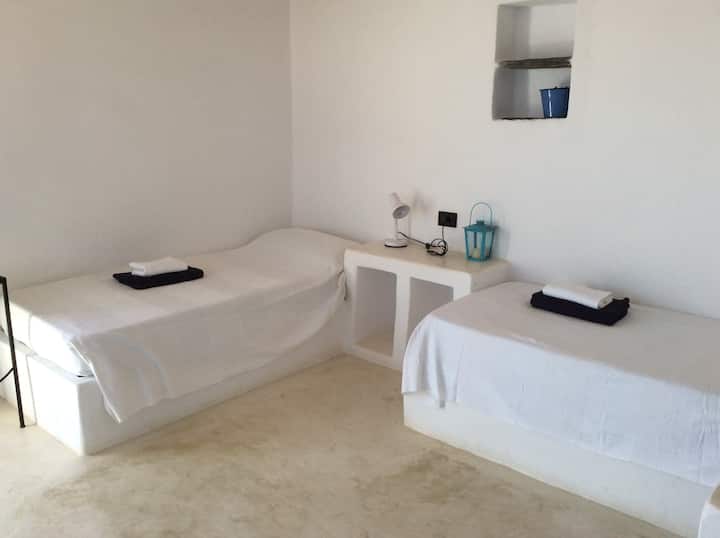 חדר שינה עם 2 מיטות יחיד וחדר רחצה פרטי