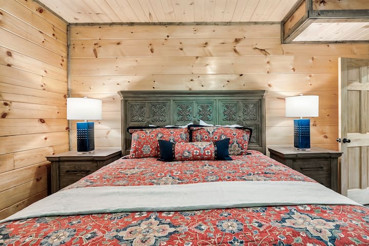 Spálňa na hlavnom poschodí má manželskú posteľ veľkosti King s inteligentnou televíziou vedľa kúpeľne.