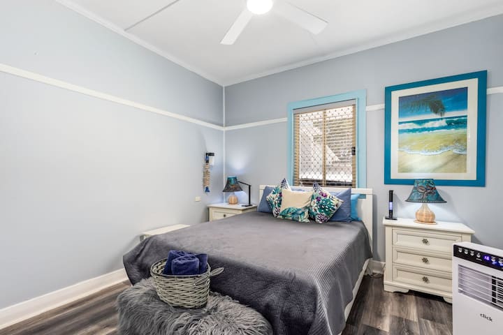 Dormitorio principal con cama tamaño queen, TV inteligente y aire acondicionado portátil.
