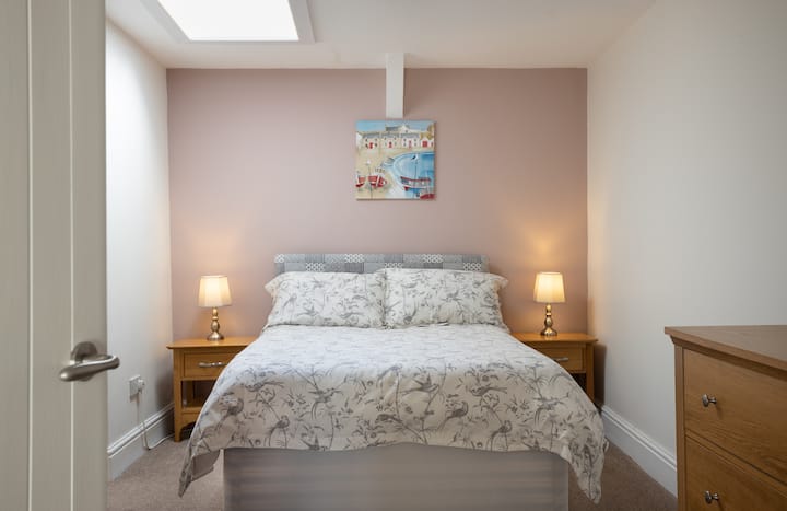 Dvojitá manželská posteľ s dvoma nočnými stolíkmi / lampami, zásuvkami a šatníkom, dverami do sprchy.