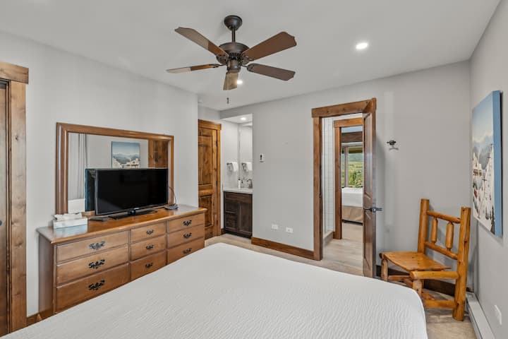 Jedna zo spální pre hostí so stropným ventilátorom a televízorom. 