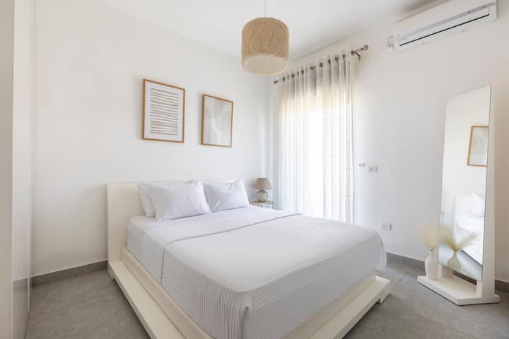 Deuxième chambre avec un lit queen size. Accès au balcon et climatisation dans la chambre.