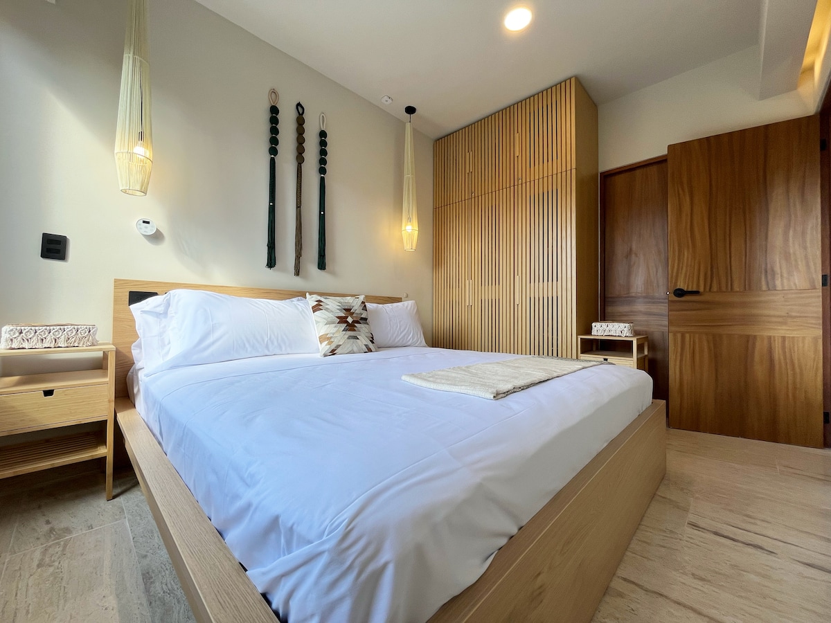 Uživajte u luksuzu uz veliki bračni krevet, svježu vrhunsku posteljinu i predivne detalje od makramea, sjenila za svjetiljke i košare za sitnice. Probudite se osvježeni u ovom mirnom penthouseu s dovoljno prostora za odlaganje u ormaru i unutarnjim sefom.