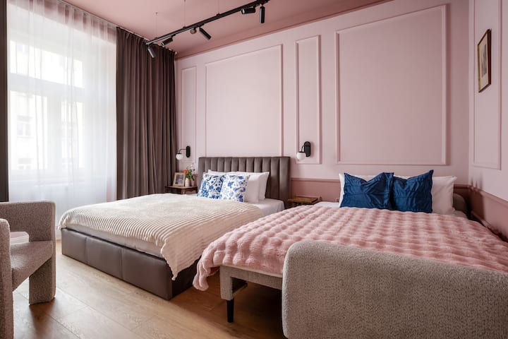 Segundo dormitorio con cama tamaño queen y sofá preparado como cama supletoria, decorado en rosa.