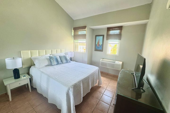 Oddýchnite si v tejto priestrannej a útulnej spálni s manželskou posteľou, mäkkým osvetlením a čiastočným výhľadom na oceán. Ideálne na pokojné noci a relaxačné rána s klimatizáciou a televízorom pre vašu zábavu.