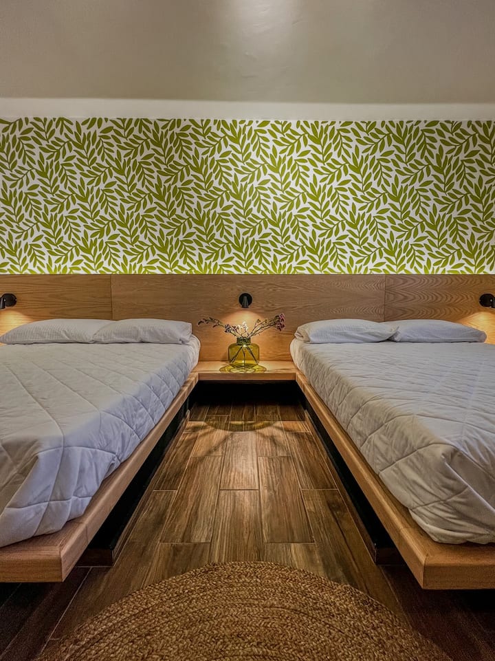 غرفة نوم كبيرة مع سريرين بحجم كوين وحمام خاص.