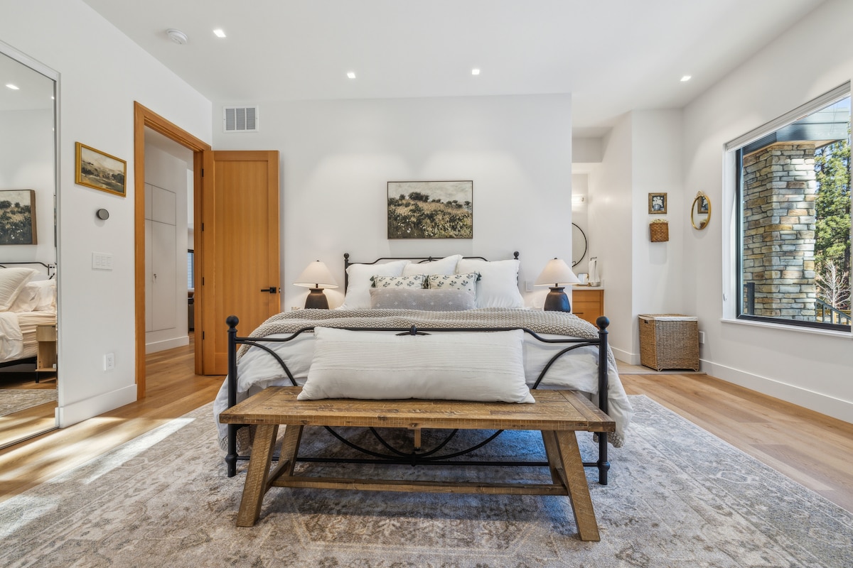 חדר שינה מפואר למטה עם אווירה כפרית - מודרנית ונעימה! תיהנו ממיטת קינג סייז מפוארת, עיצוב אלגנטי וחלונות גדולים שמביאים אור טבעי ונופי יער מדהימים. מקום הנופש ההררי המושלם שלכם מחכה!