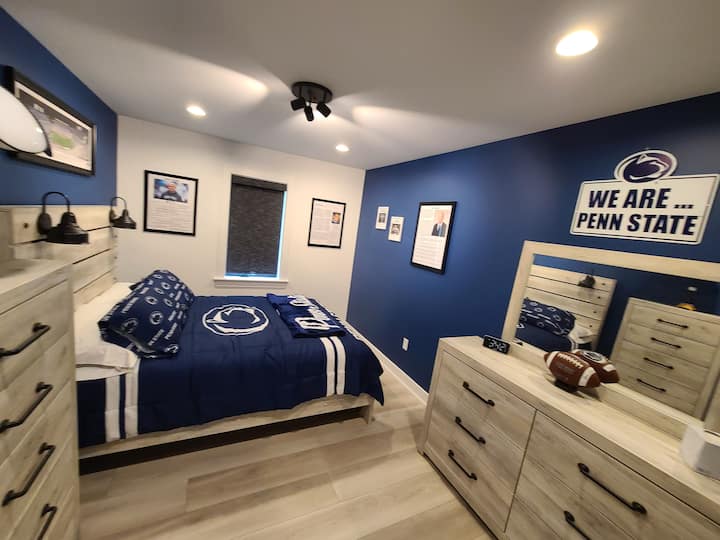 Penn State themed room features a queen bed and dimmable lights. The rooms proudly displays coach and athlete bios, a Paterno autographed football and a photo of a "white out" game in Beaver Stadium