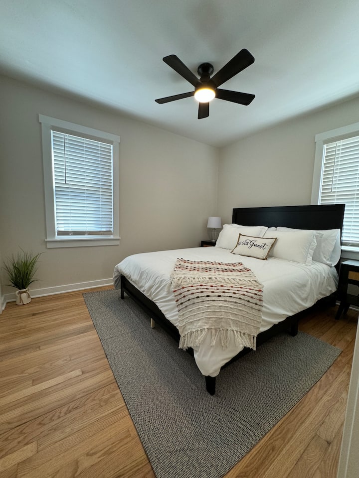 Dormitorio queen con 2 mesitas de noche que tienen USB y enchufes para todas tus necesidades de carga.  Se proporciona un portaequipajes y ganchos en el armario.  También encontrarás juegos de mesa en el armario de este dormitorio.