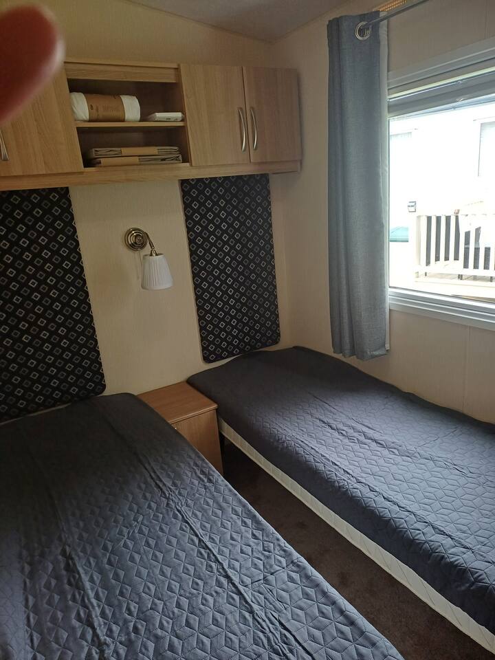 两张单人床，一张床头柜。  一个带架子和衣架的衣柜。