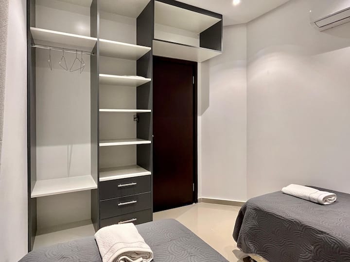 Disfruta de esta encantadora habitación con dos camas individuales y un amplio armario a medida.  El aire acondicionado garantiza comodidad, haciendo de este espacio un refugio perfecto durante tu estancia.