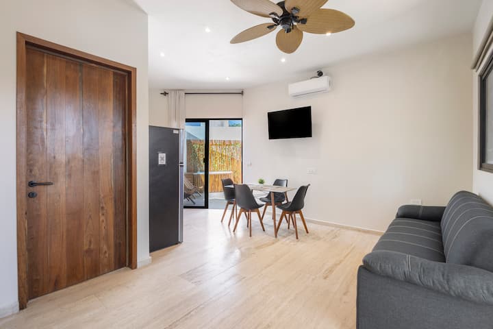 Sala con sofá cama y mesa de comedor, terraza privada con jacuzzi y balcón.