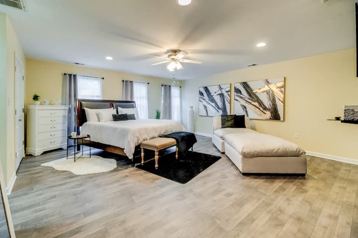 Master bedroom featuring a luxurious king-size bed, three spacious closets, and an en-suite private bathroom. Enjoy cozy movie nights on the large, comfortable lounge couch, perfect for relaxing and snuggling.