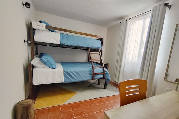 Pangalawang kuwartong may double bunk at single para sa 3 tao. Wardrobe, tv, fan. Translucida curtains and black out ideal for access to natural light and at the same time have privacy. Desk at multicontactos para sa home office. 