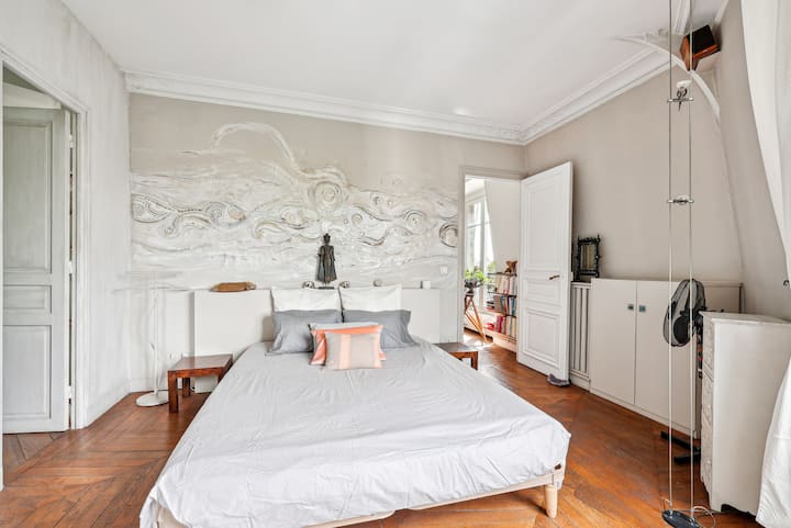 Spacious bedroom with double bed and wall lights at the head of the bed.