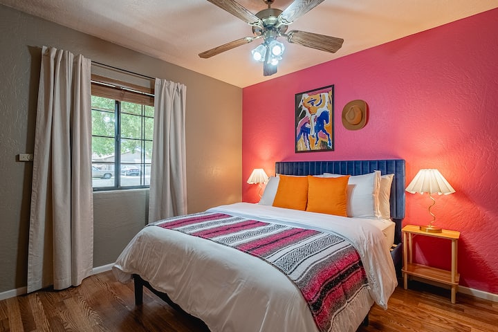 Disfruta de un retiro tranquilo en este acogedor dormitorio con una cama tamaño queen, un ventilador de techo para mayor comodidad y una ventana adornada con cortinas que permiten la cantidad justa de luz natural.