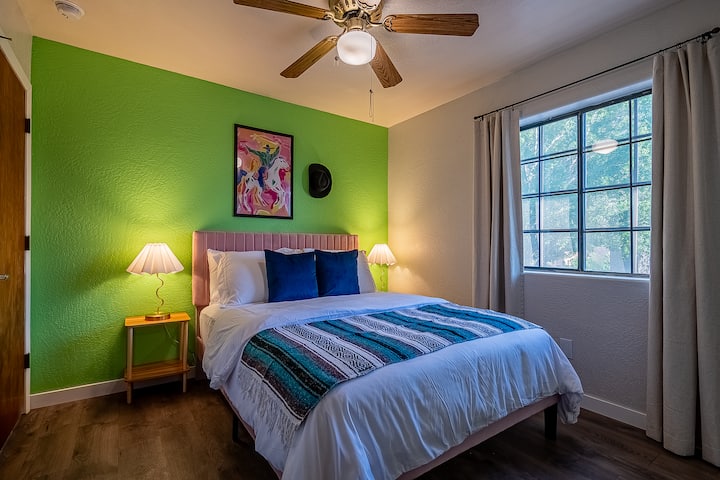 Relájate en este acogedor dormitorio con una cama tamaño queen, un refrescante ventilador de techo y lujosas sábanas que prometen un sueño cómodo y reparador.
