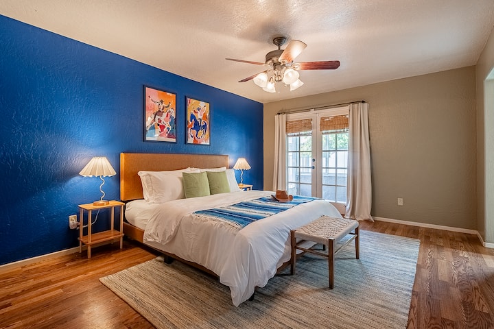 Relájate en este acogedor dormitorio, con una cama tamaño king, un ventilador de techo refrescante y ventanas espaciosas que crean un ambiente luminoso y tranquilo.