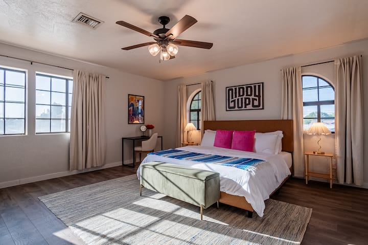 Relájate en el dormitorio principal, con una lujosa cama tamaño king, un refrescante ventilador de techo y grandes ventanales que llenan el espacio con luz natural.
