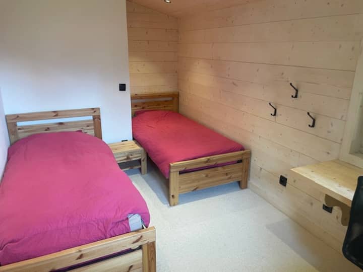 חדר שינה ראשון למעלה עם 2 מיטות יחיד, שולחן כתיבה, כיסא משרדי, שידת לילה. מקום אחסון גדול עם תלייה כפולה וארונות כפולים. 